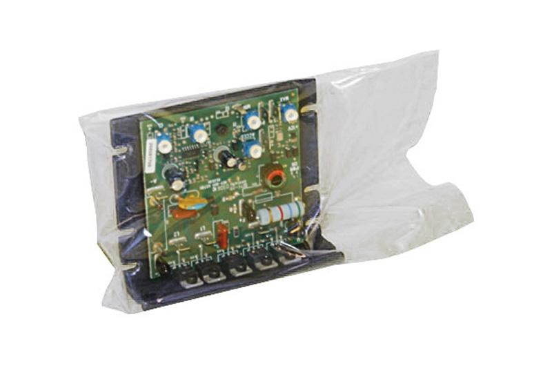 An electronic circuit board with various components is encased in a clear plastic bag, viewed from a slight angle against a white background.
