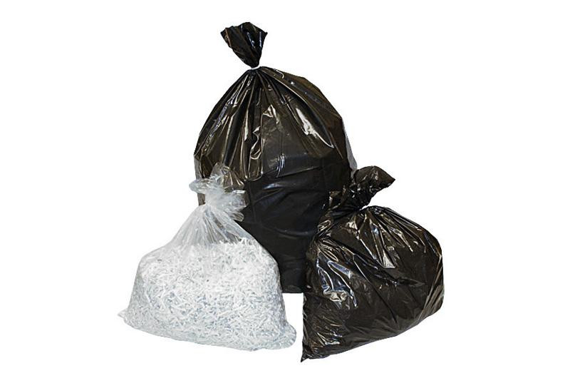 Three garbage bags: two large black plastic bags and one smaller transparent bag containing shredded white paper.