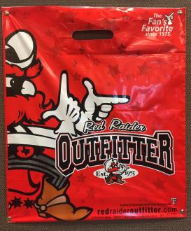 Red plastic shopping bag featuring a cartoon cowboy mascot, the text "Red Raider Outfitter," and promotional slogans in white and black lettering.