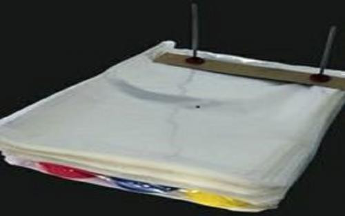 A stack of white plastic bags held together by a metal bar with two vertical rods against a black background.