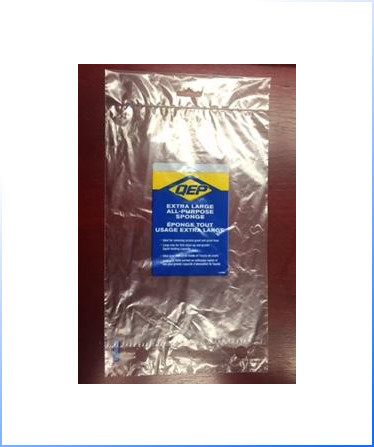 Clear Wicket Bag – a package labeled "QEP Extra Large All-Purpose Sponge" is sealed inside a clear plastic bag on a wooden surface.