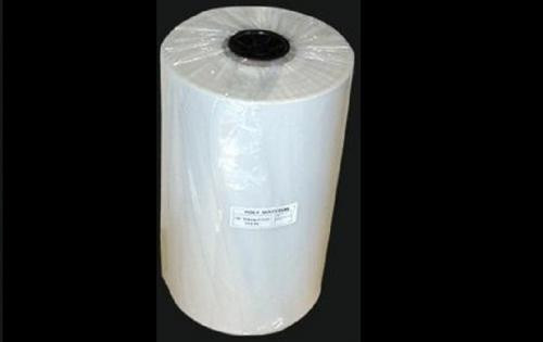 Large roll of clear plastic film with a label on the side, wrapped around a black central core, against a black background.